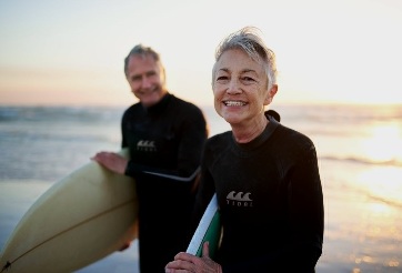 Couple standing with surfboards at the beach